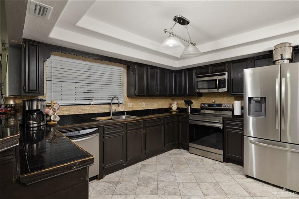 26813 Solis Road La Feria, TX 78559 - Photo 8 of 33 a kitchen with granite countertop stainless steel appliances and wooden cabinets