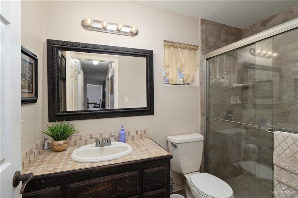 26813 Solis Road La Feria, TX 78559 - Photo 10 of 33 a bathroom with a toilet a sink and mirror
