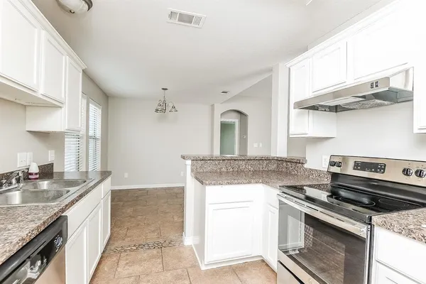 a kitchen with stainless steel appliances granite countertop a sink stove and cabinets