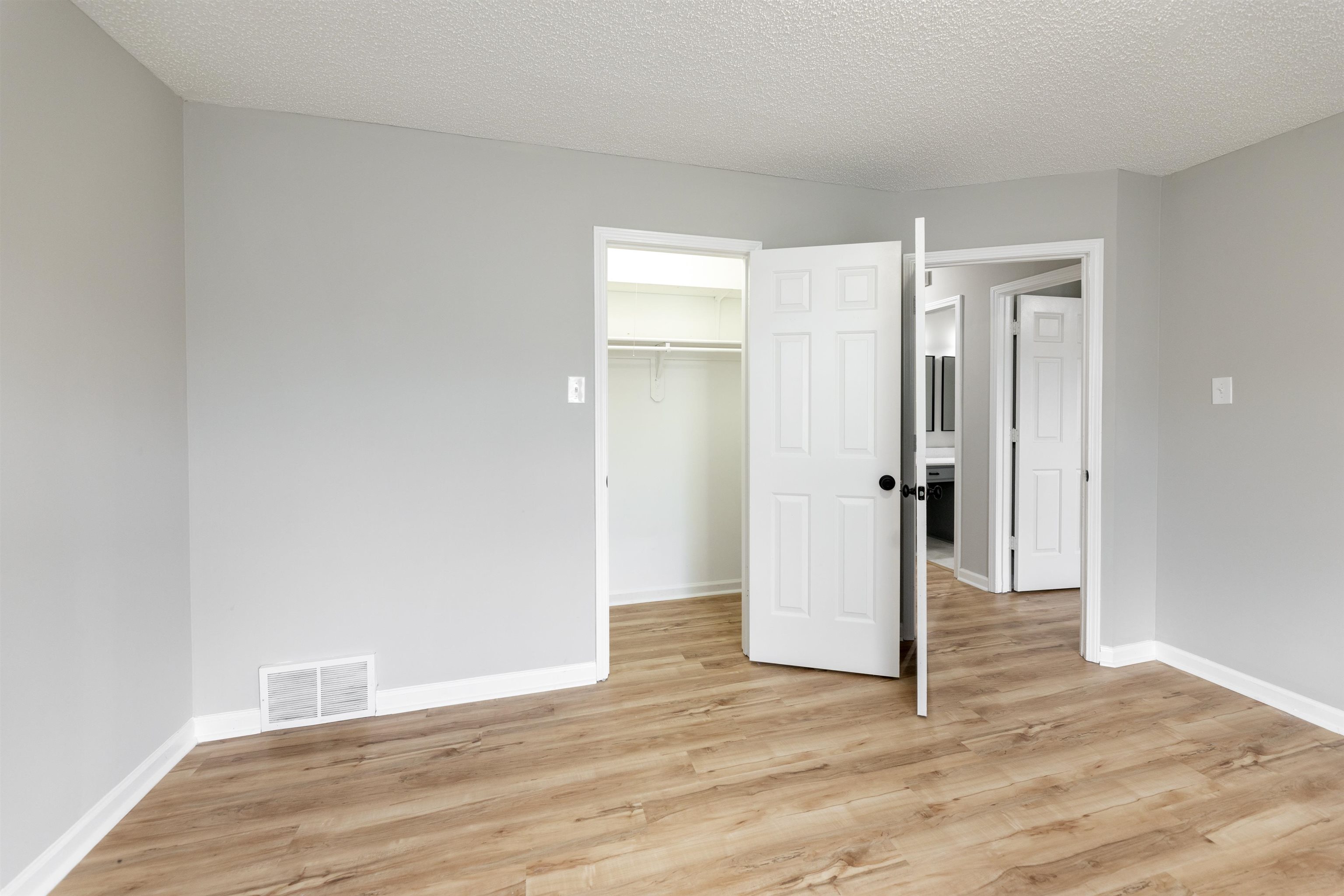 7421 Richmond Road Memphis, TN 38125 - Photo 15 of 39 Room featuring light gray walls, wood-finish flooring, white baseboards, and a white popcorn ceiling