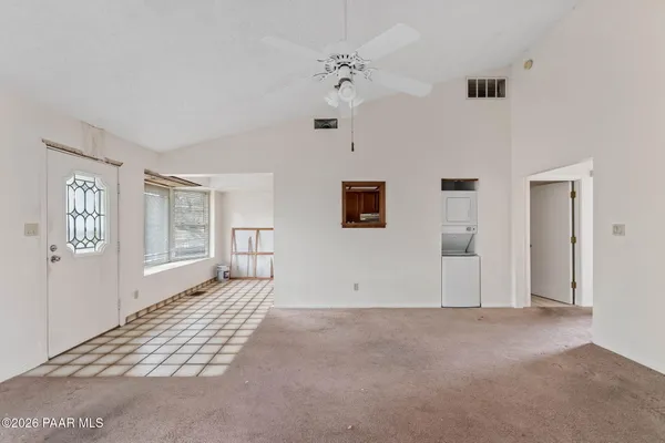 an empty room with windows and ceiling fan