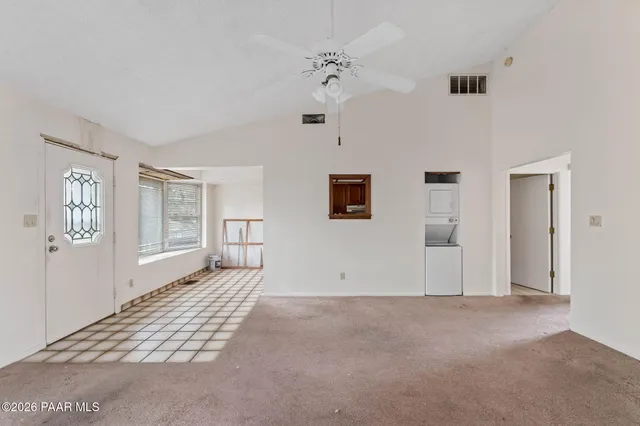 an empty room with windows and ceiling fan