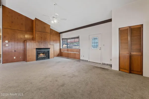 a view of an empty room with a fireplace and a window