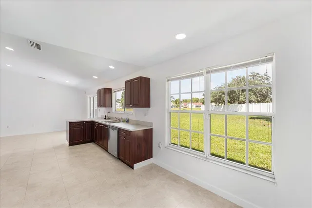 a large white kitchen with a large window and sink