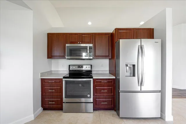a kitchen with appliances a refrigerator and cabinets