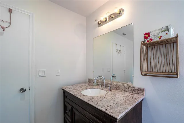 a bathroom with a granite countertop sink and a mirror