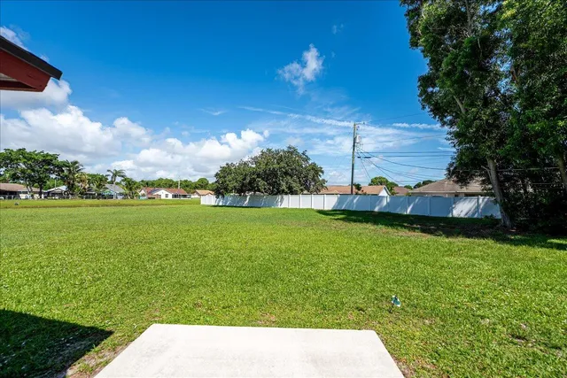 a view of yard with swimming pool and green space