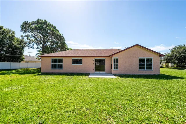a view of a yard in front of a house with large trees