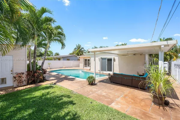a view of house with backyard and outdoor seating