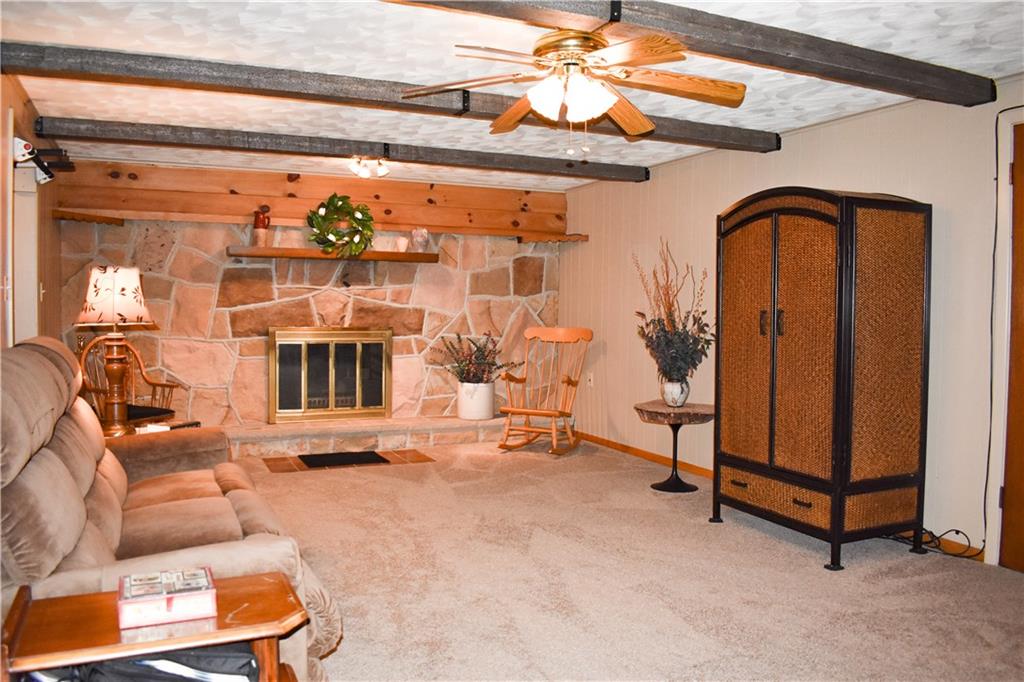 113 Morningside Drive Butler, PA 16002 - Photo 16 of 25 Lower level family room with gorgeous stone fireplace. Freshly painted with a nice ceiling light fan and faux beams complete the room. Neutral carpet and paint.
