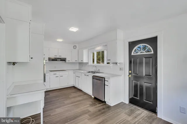 a kitchen with a refrigerator sink and cabinets