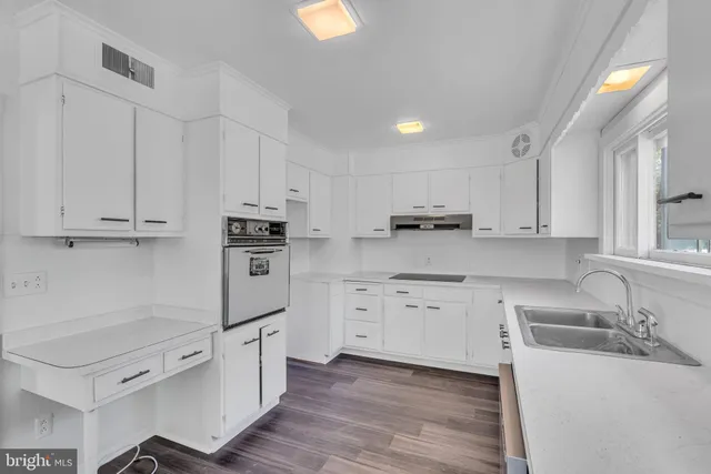 a kitchen with granite countertop a sink stainless steel appliances and cabinets