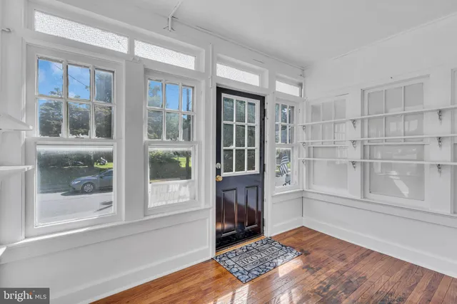 a view of a bedroom with a balcony and wooden floor