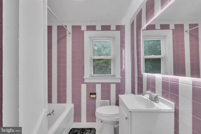 a bathroom with a sink toilet and window