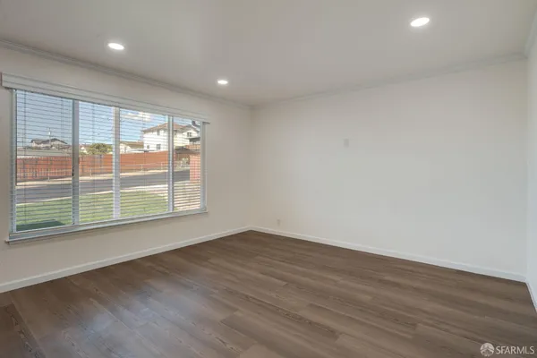 a view of an empty room with wooden floor