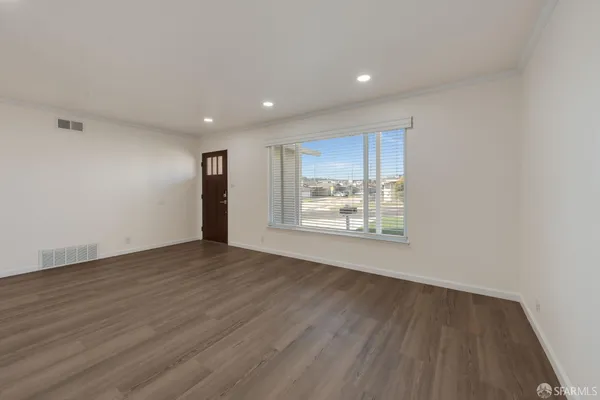 a view of an empty room with wooden floor