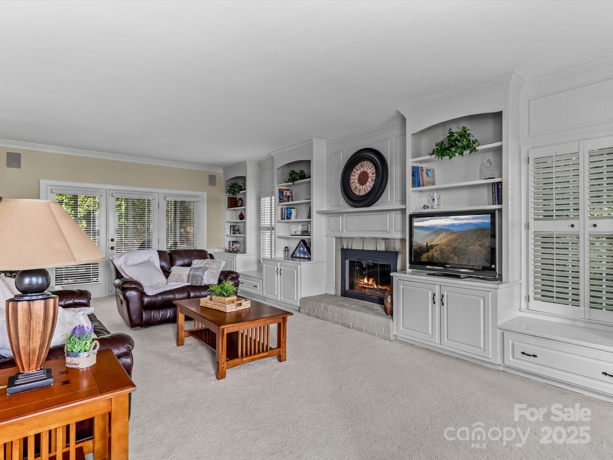 806 Lake Mist Drive Stanley, NC 28164 - Photo 12 of 47 a living room with furniture a flat screen tv and a fireplace with a bookshelf