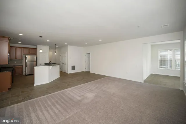 a spacious bedroom with a bed a couch and a potted plant