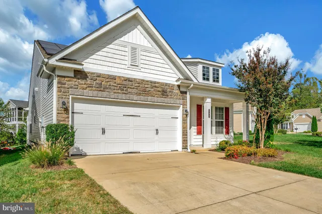 a view of a house with a yard and potted plants