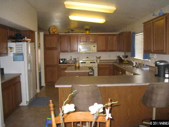 17780 Fairfax Court Reno, NV 89508 - Photo 2 of 13 a kitchen with stainless steel appliances granite countertop a sink refrigerator and cabinets