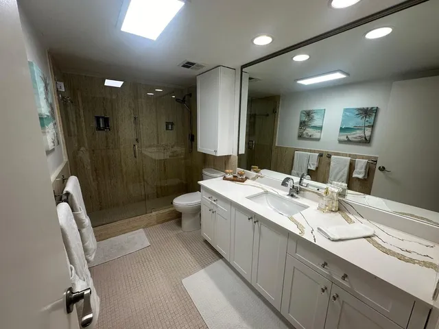 a bathroom with a double vanity sink toilet and shower
