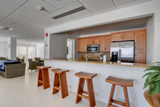 a kitchen with furniture a counter top space stainless steel appliances and living room view