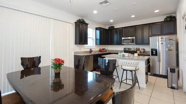 a kitchen with kitchen island granite countertop a sink stove and refrigerator