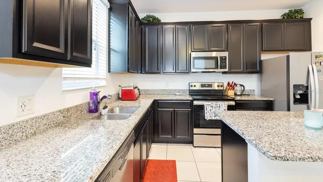 a kitchen with kitchen island granite countertop a sink stove and refrigerator