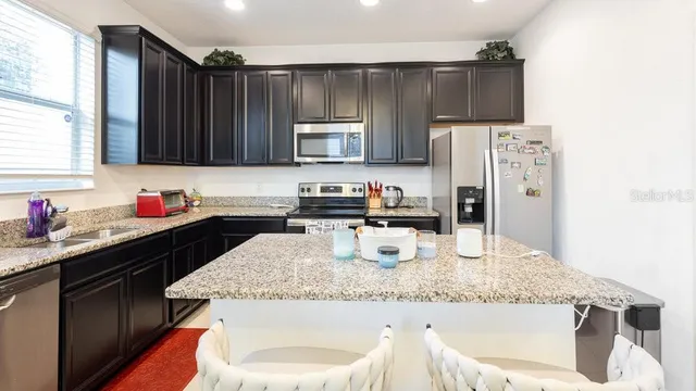a bathroom with a granite countertop sink a toilet and a mirror
