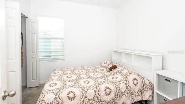 a view of a bedroom with a bed and a window