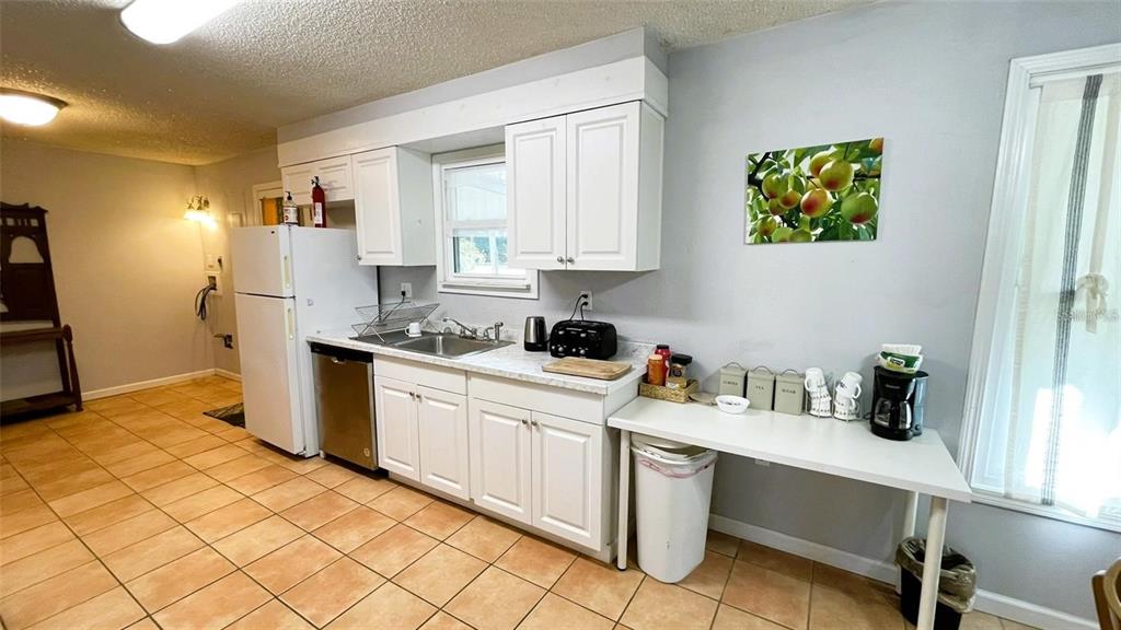 151 Twin Lakes Road Hawthorne, FL 32640 - Photo 5 of 28 a kitchen with a refrigerator and cabinets
