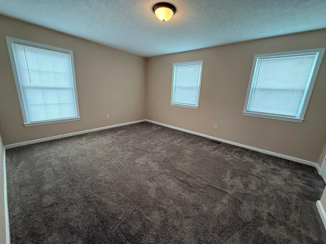 an empty room with window and mirror