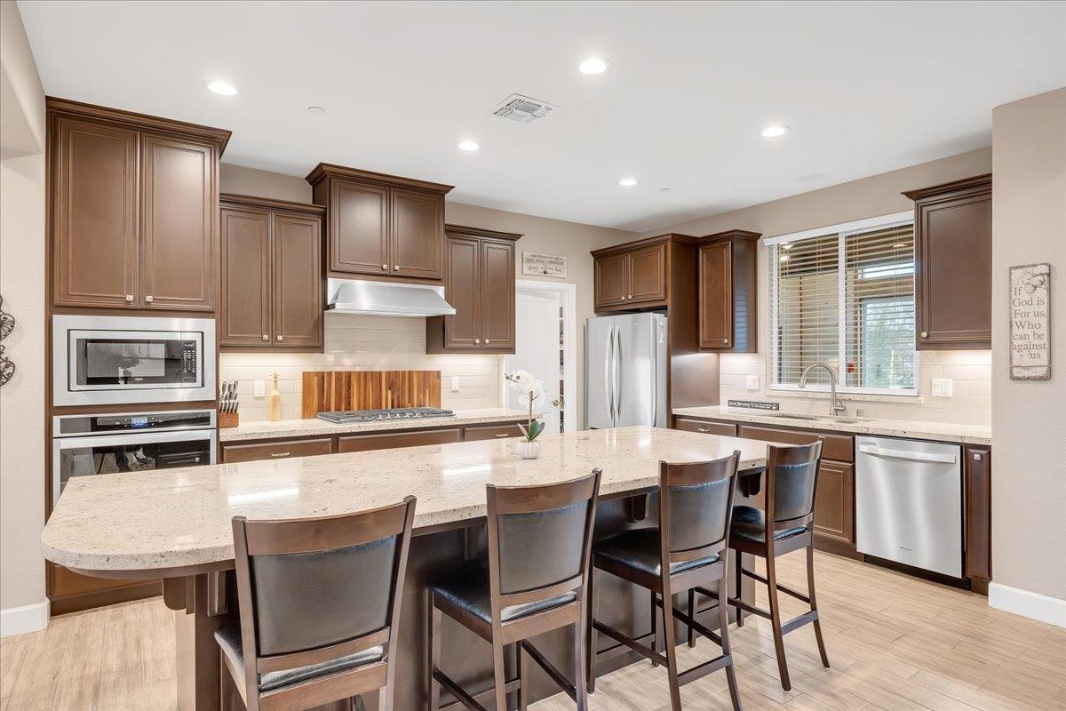 133 Palisades Place Copperopolis, CA 95228 - Photo 25 of 95 a kitchen with stainless steel appliances kitchen island granite countertop a stove a refrigerator a sink a dining table and chairs