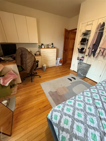 a bedroom with a bed and wooden floor