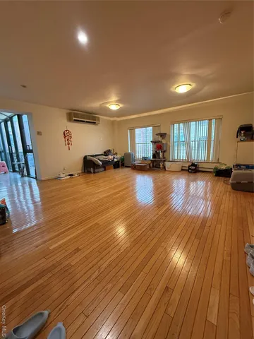 a view of a room with wooden floor and window