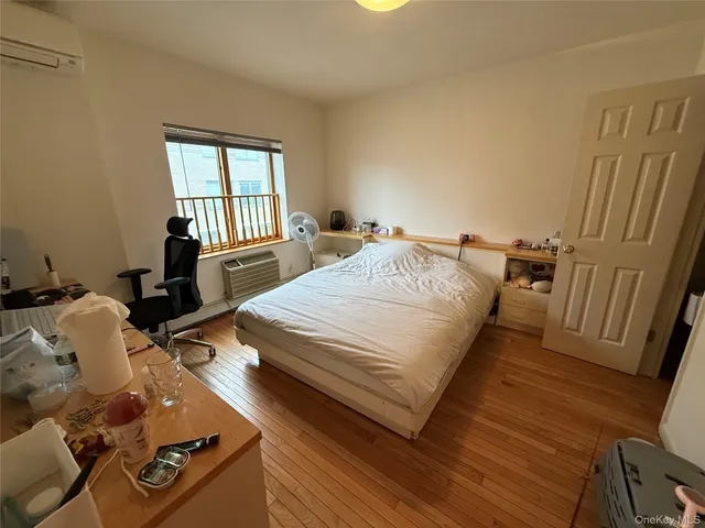a bedroom with two beds and wooden floor