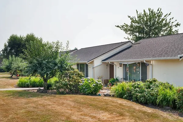 a front view of house with yard and trees around