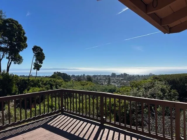 a view of a balcony with wooden floor and fence