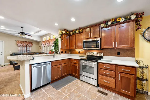 a kitchen with granite countertop a sink stainless steel appliances and cabinets