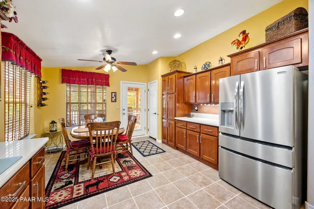 a kitchen with stainless steel appliances refrigerator dining table and chairs