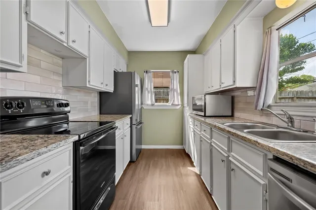 a kitchen with a sink stove top oven and cabinets