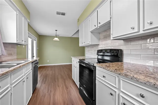 a kitchen with granite countertop wooden cabinets and a stove