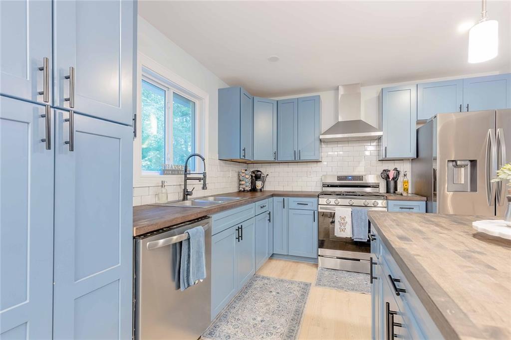 6375 Caladium Drive Acworth, GA 30102 - Photo 11 of 41 a kitchen with stainless steel appliances granite countertop a sink stove and refrigerator