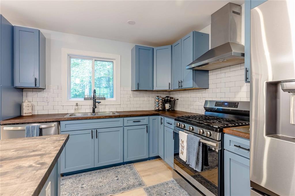 6375 Caladium Drive Acworth, GA 30102 - Photo 12 of 41 a kitchen with stainless steel appliances granite countertop a sink stove and refrigerator