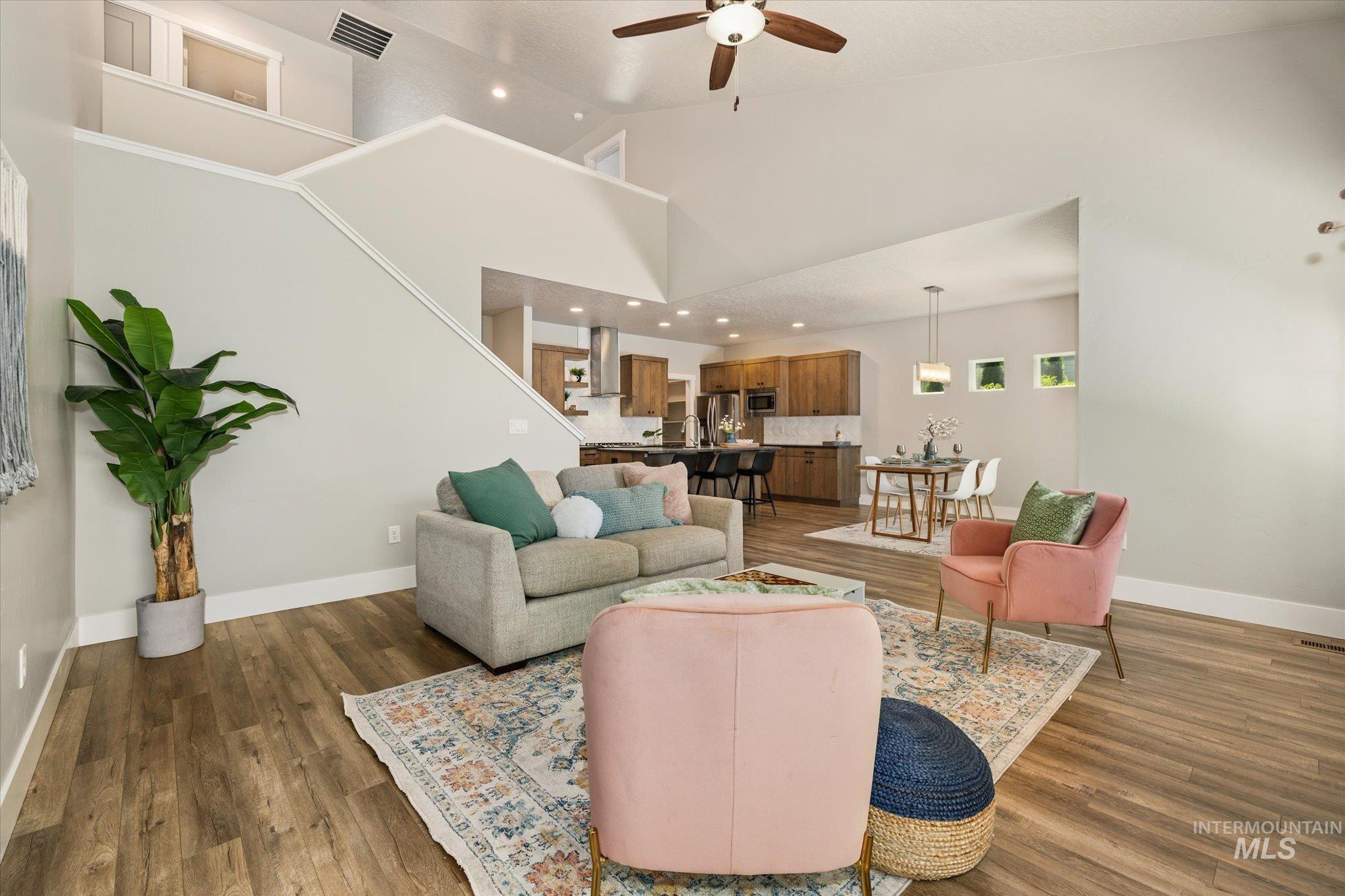 1915 South High Street Boise, ID 83706 - Photo 12 of 44 Great room featuring wood-finish flooring, a vaulted ceiling with a ceiling fan, and a staircase with a white railing