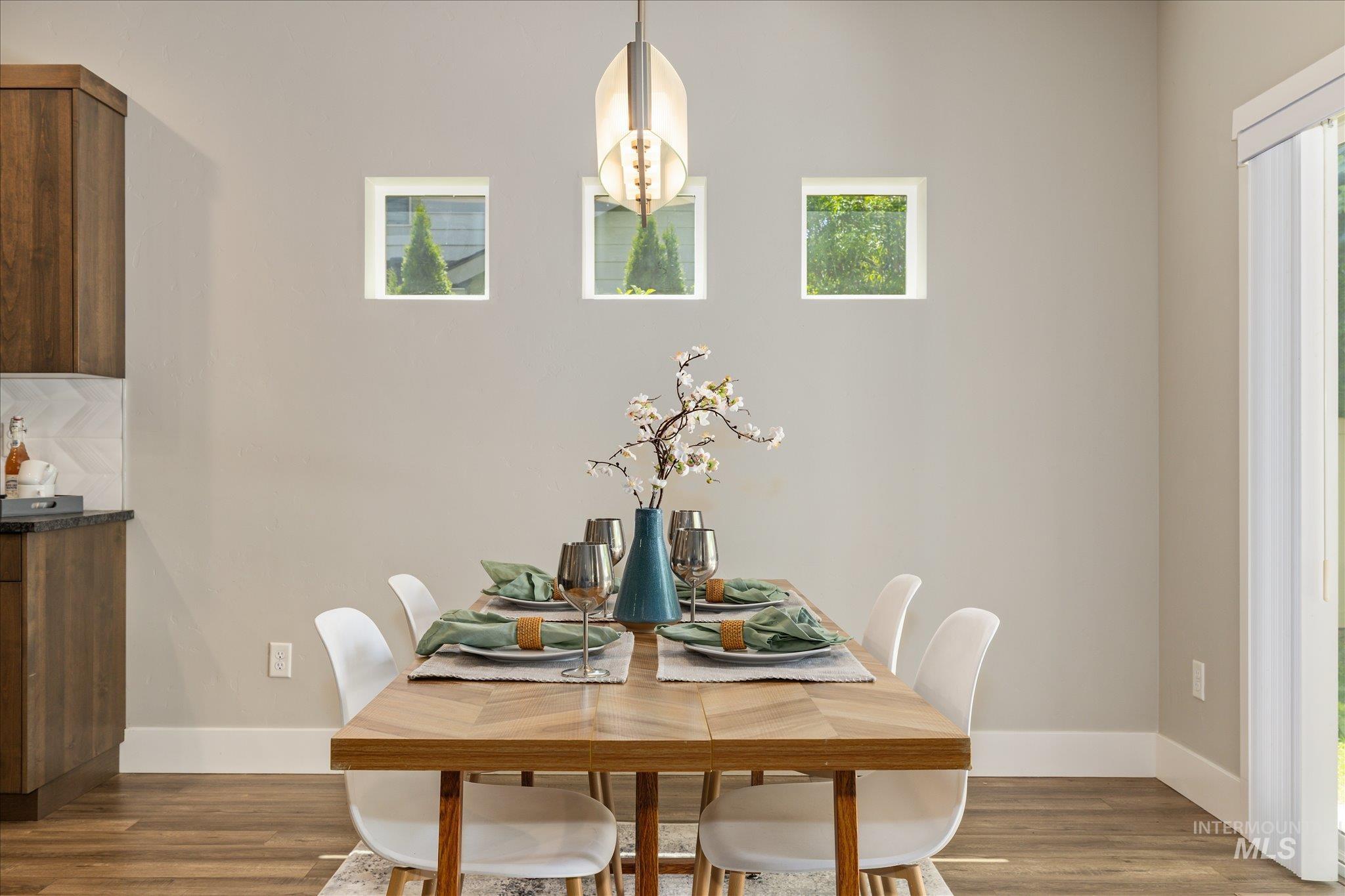 1915 South High Street Boise, ID 83706 - Photo 15 of 44 Dining area with wood-finish flooring, a contemporary pendant light fixture, and three square accent windows