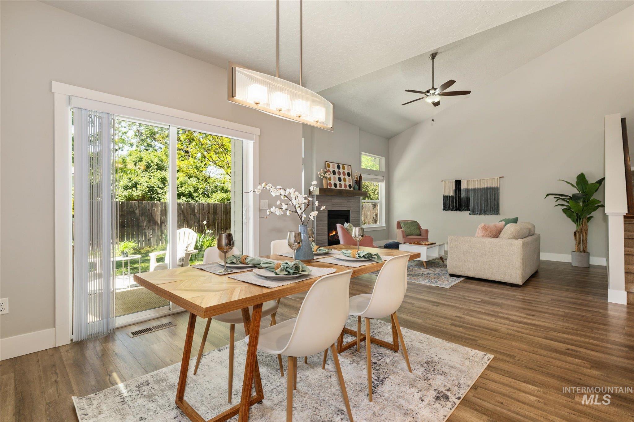 1915 South High Street Boise, ID 83706 - Photo 17 of 44 Open-concept interior featuring wood-finish flooring, a dining area with a linear chandelier, and a living area with a vaulted ceiling