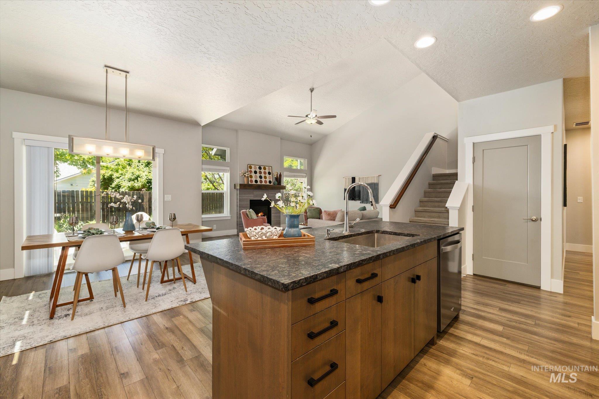 1915 South High Street Boise, ID 83706 - Photo 21 of 44 Kitchen island featuring a stainless steel sink, dark stone countertop, and wood-finish cabinetry