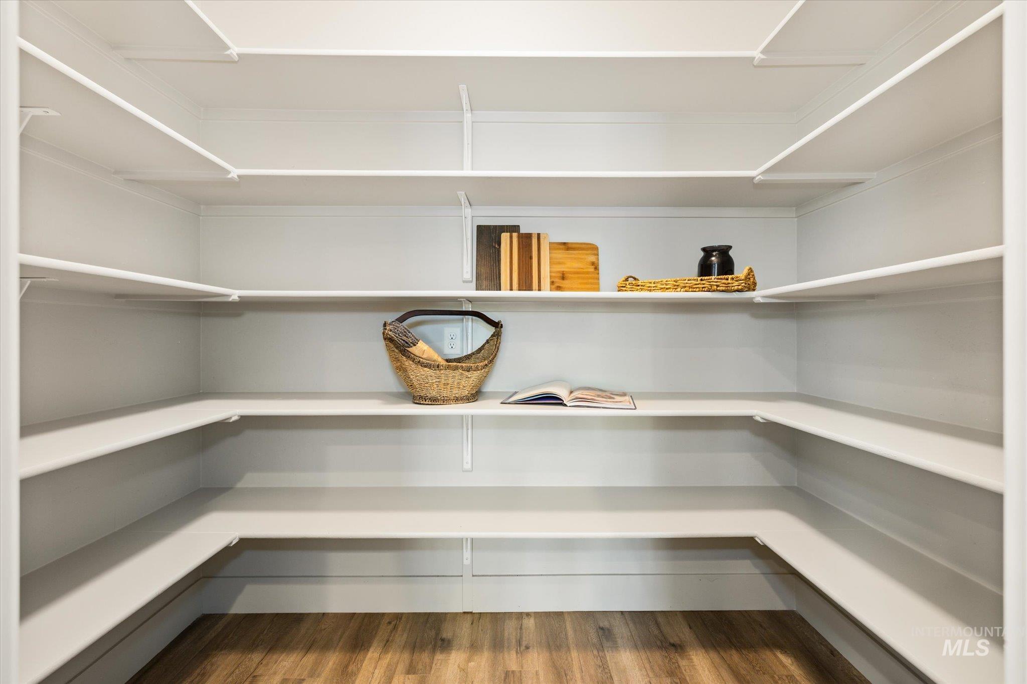 1915 South High Street Boise, ID 83706 - Photo 25 of 44 Custom-built pantry featuring extensive U-shaped shelving, solid wood-finish flooring, and white painted walls