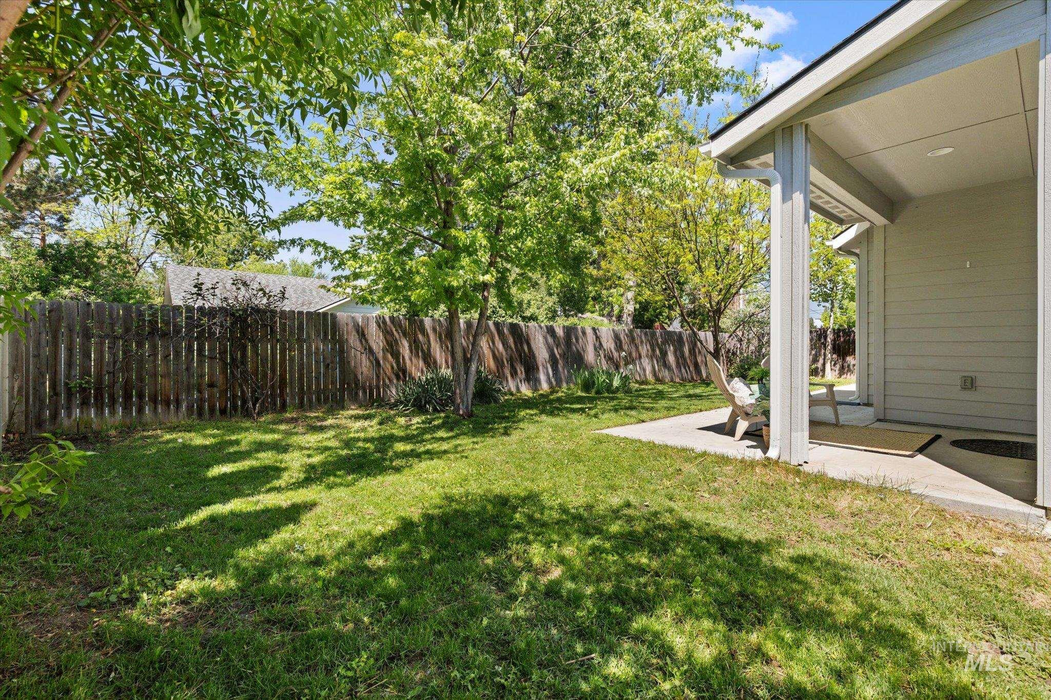 1915 South High Street Boise, ID 83706 - Photo 33 of 44 Private backyard featuring a wood privacy fence, mature trees, and a concrete patio